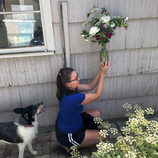 A mom holds up her bouquet after receiving it for delivery on Mother's Day