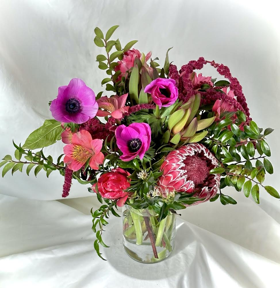 Locally grown pink and magenta flowers  arranged in a medium vase for Valentine’s Day delivery. Lush greenery with pops of different pink.